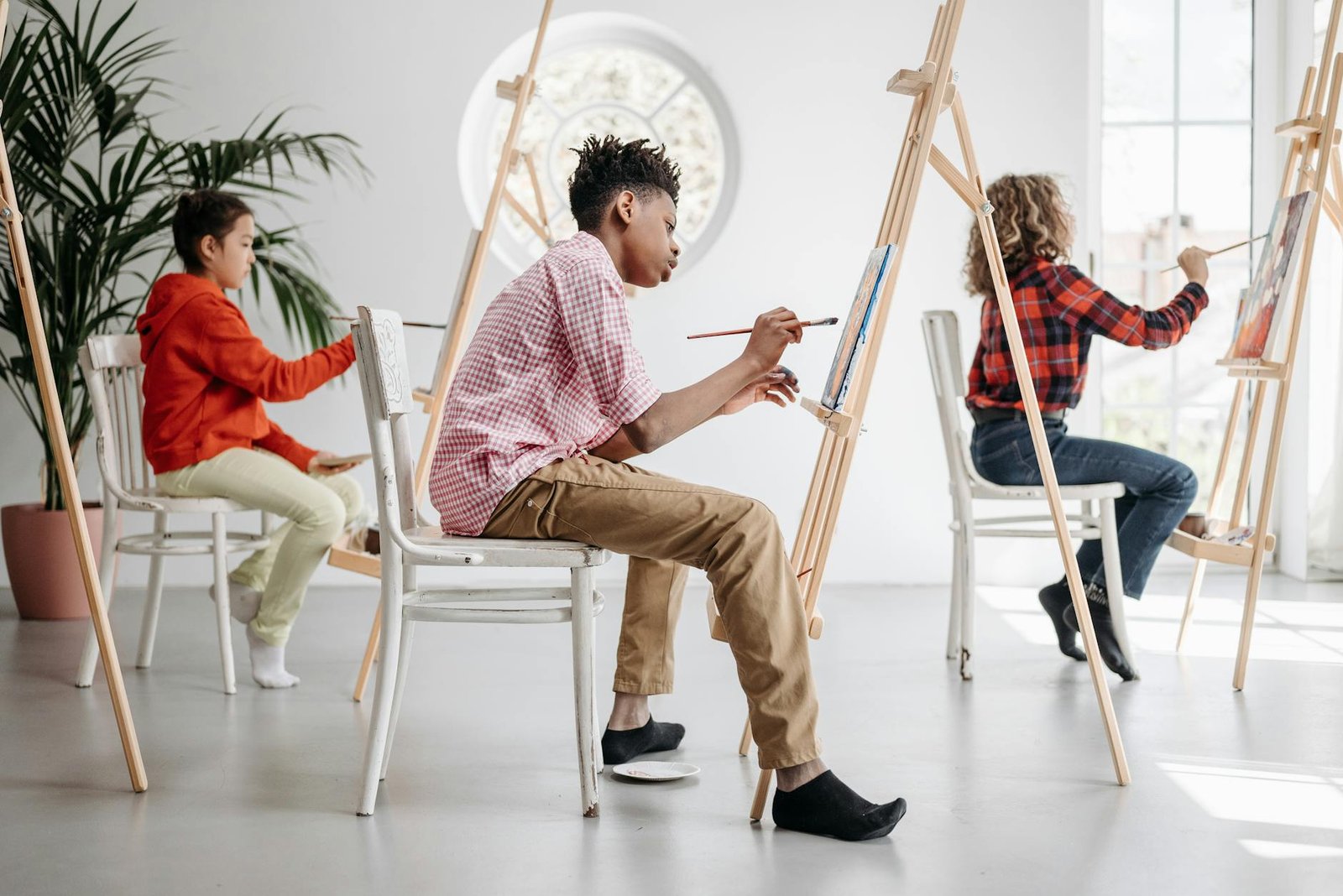 Children painting at easels in an art class