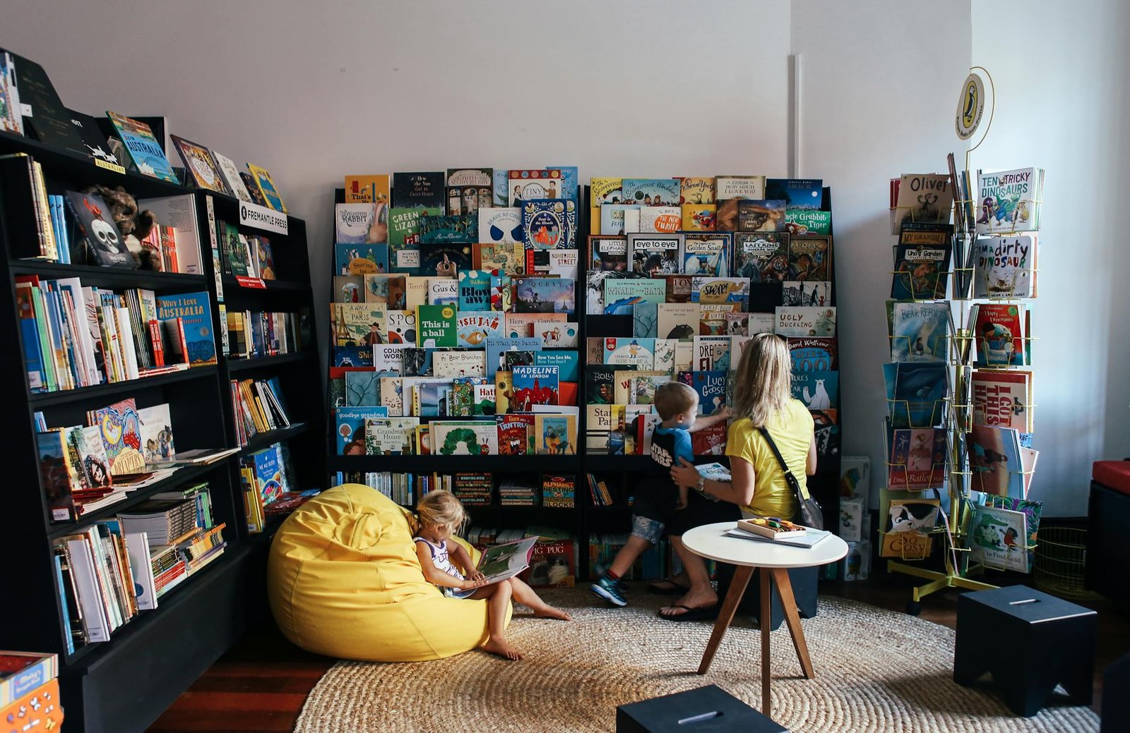 Mother and children reading books together in a library